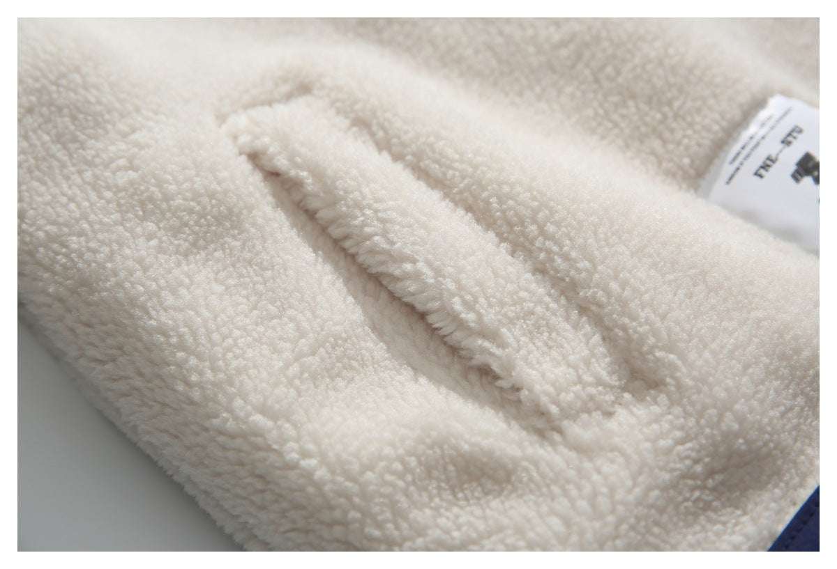 Close-up of a pocket opening on cream sherpa fabric.