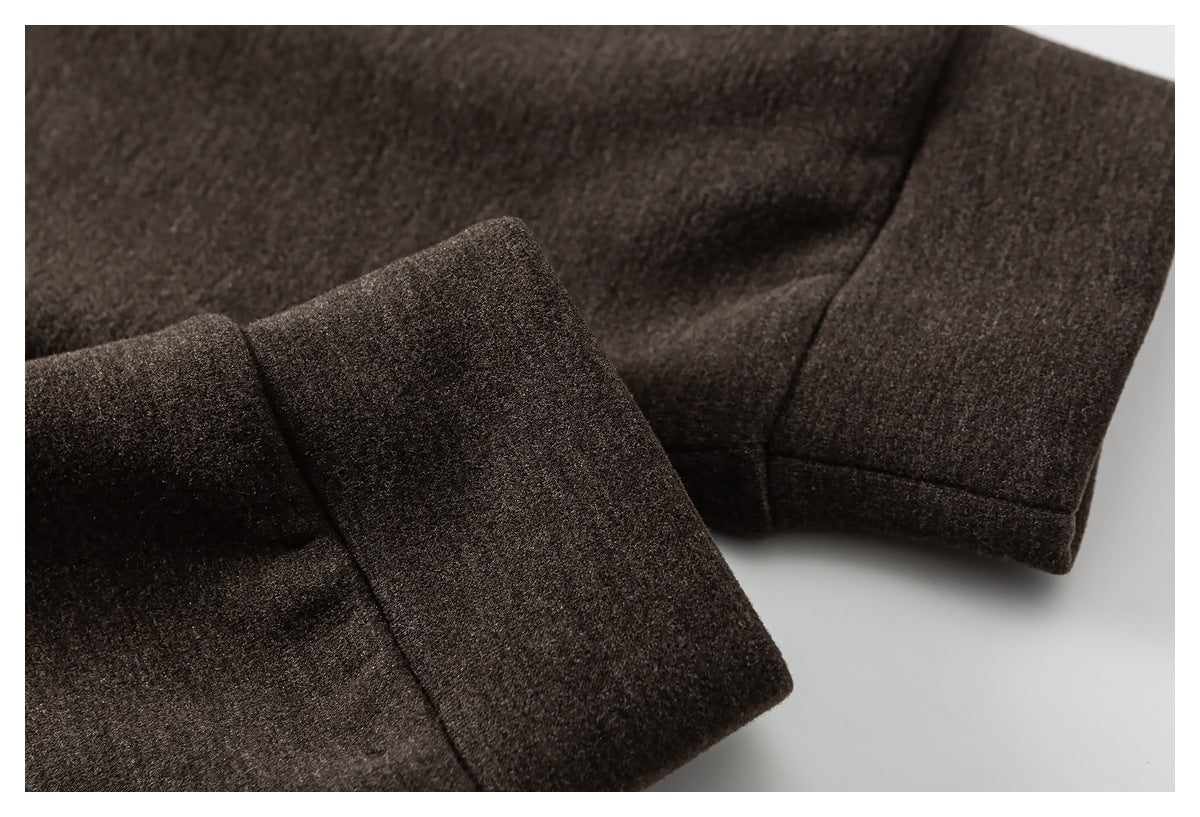 Close-up of a dark brown coat sleeve cuff and stitched seam.