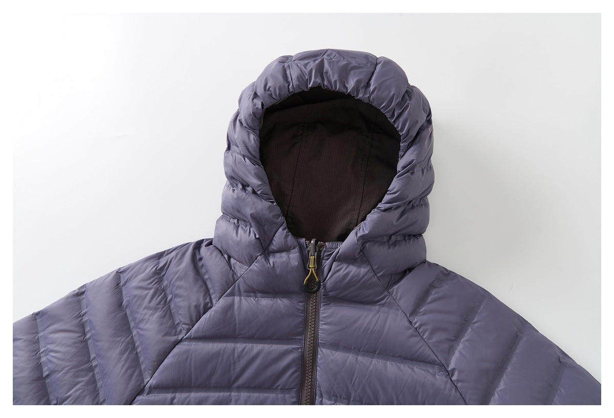 Upper front of a muted lavender-gray quilted jacket with a hood, dark lining, and front zipper.