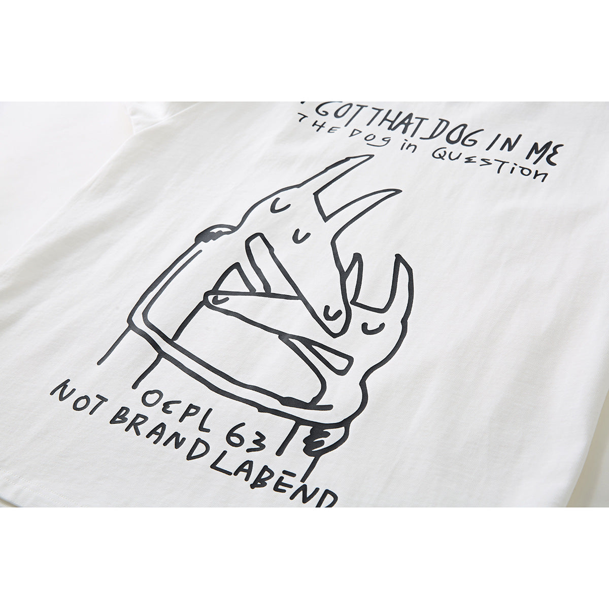 Close-up of an off-white T-shirt’s black line-art dog graphic and English lettering.