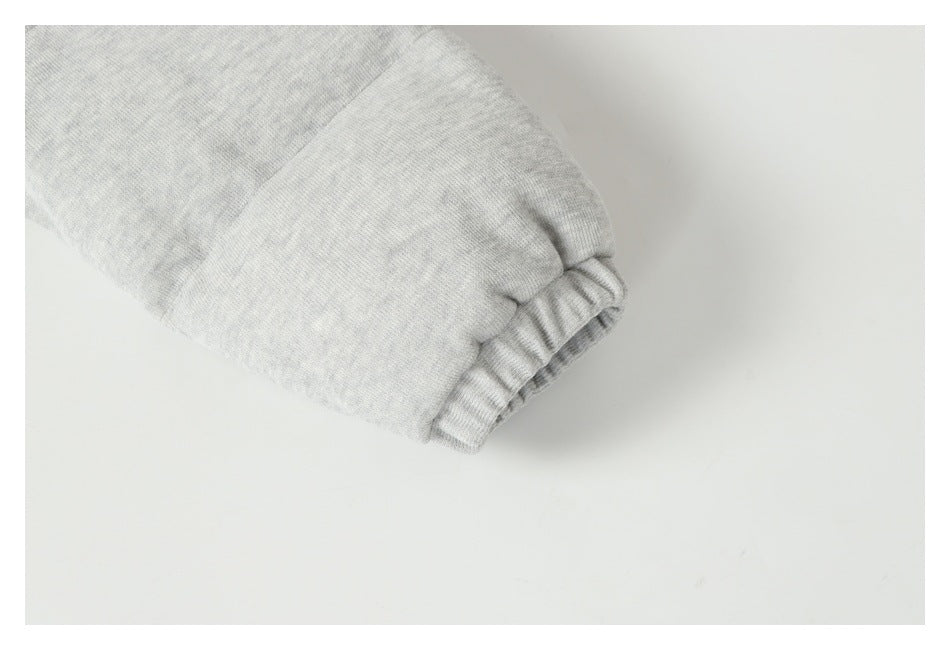 Close-up of a light gray sleeve ending in a gathered ribbed cuff.
