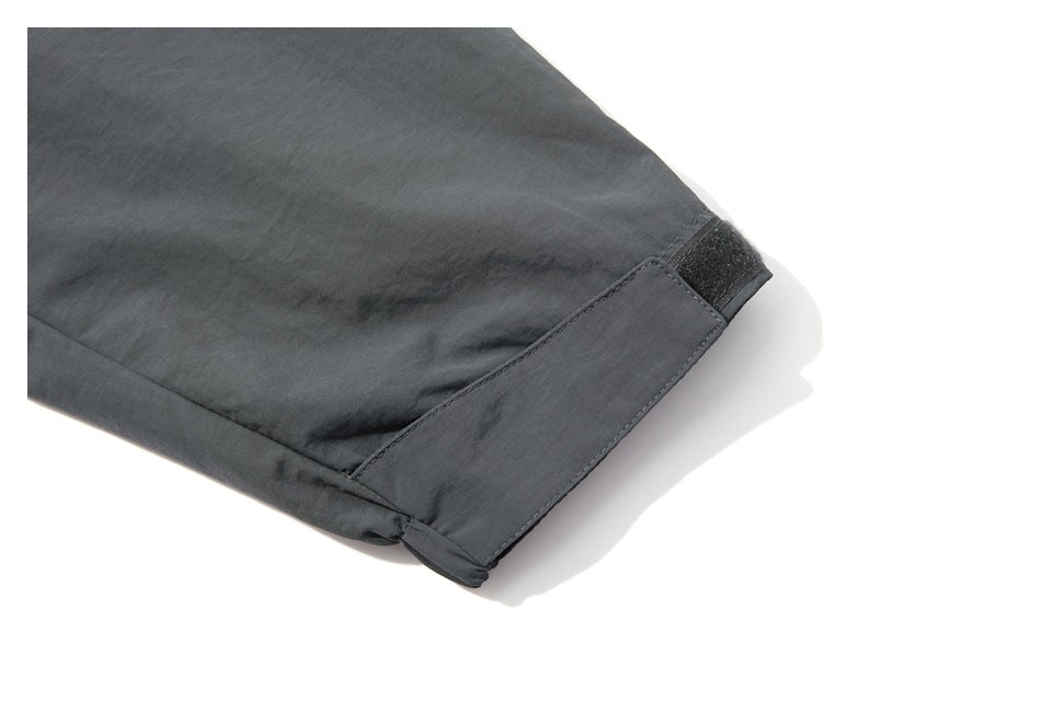 Close-up of a charcoal-gray jacket sleeve cuff with an adjustable hook-and-loop tab.