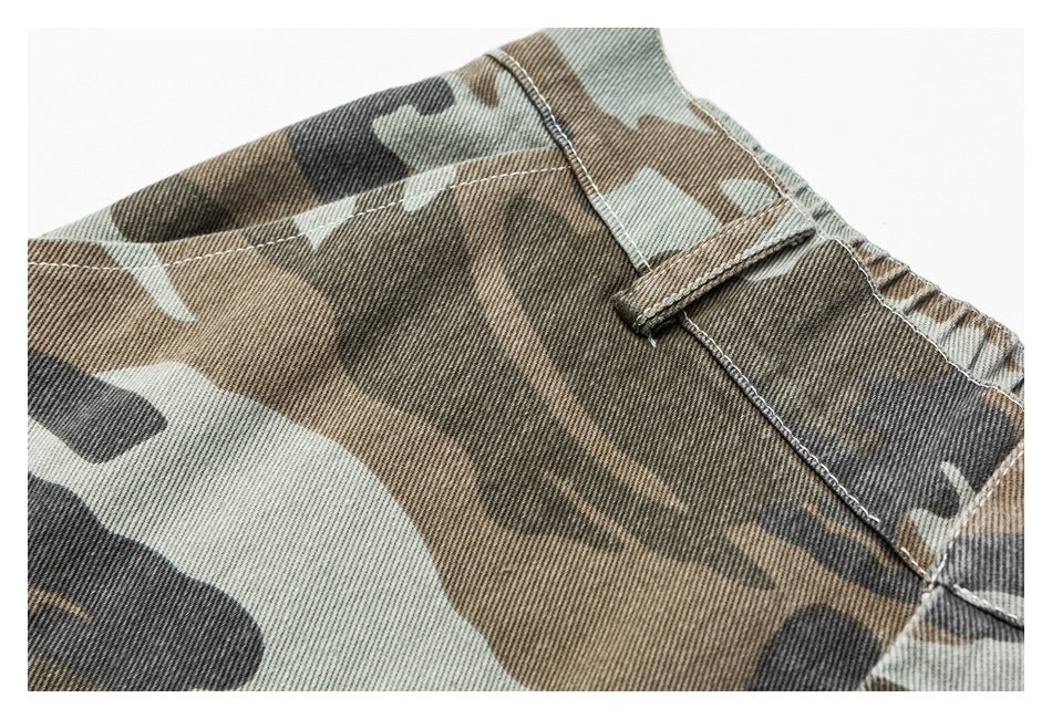Close-up of a belt loop and stitched waistband on brown, black and sage camouflage trousers.