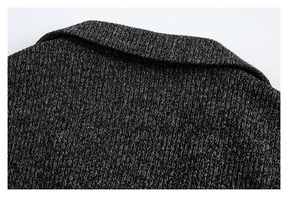 Close-up of a folded collar or neckline edge on a dark charcoal knit garment.
