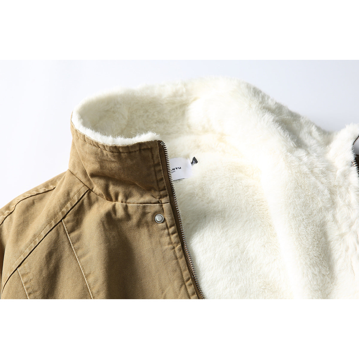 Close-up of a tan jacket collar and zipper, showing the thick white plush lining and inner label.