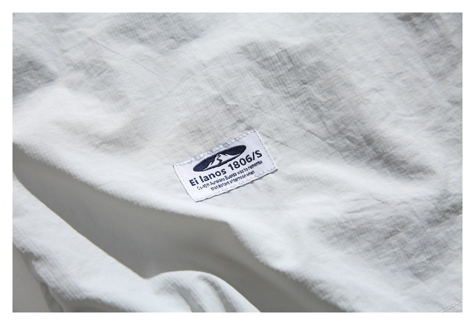 Close-up of pale gray woven fabric with a small sewn brand label.