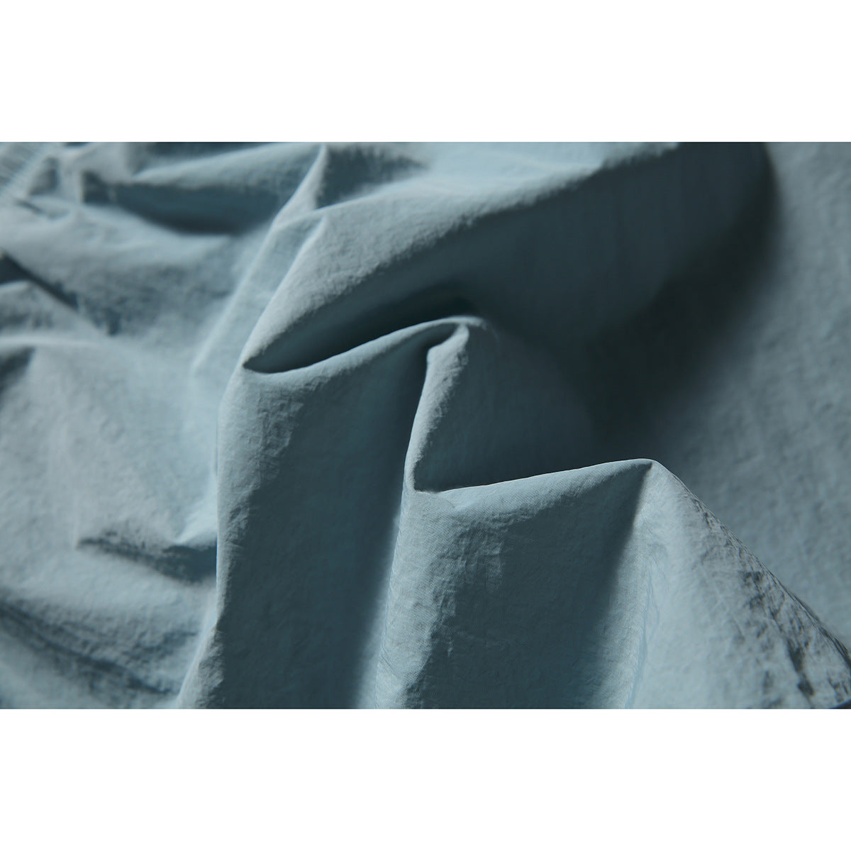Macro view of the softly crinkled blue-gray skirt fabric and its folds.