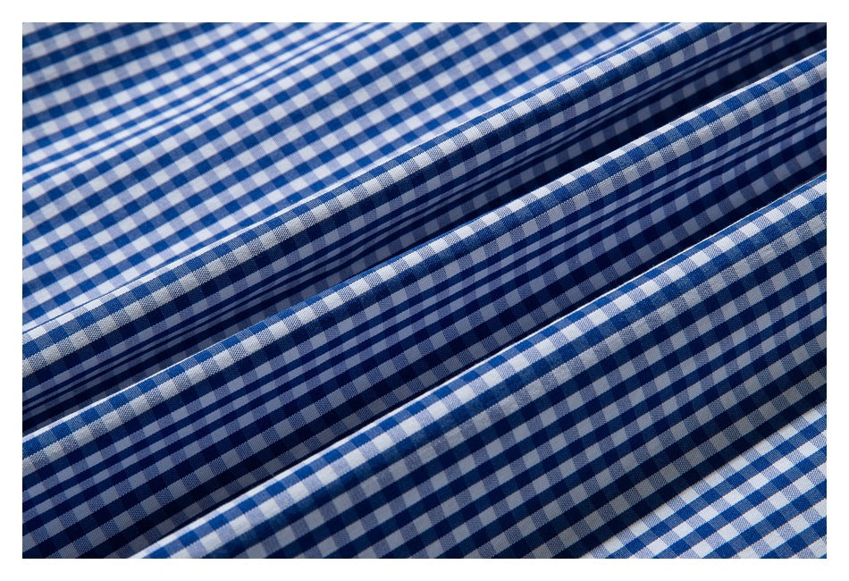 Close-up of blue-and-white gingham fabric arranged in parallel folds.