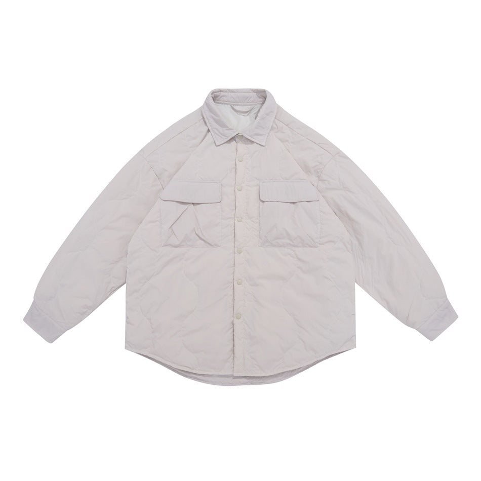 Front view of a pale blush-cream quilted shirt jacket with a pointed collar, snap buttons, two flap chest pockets, and long