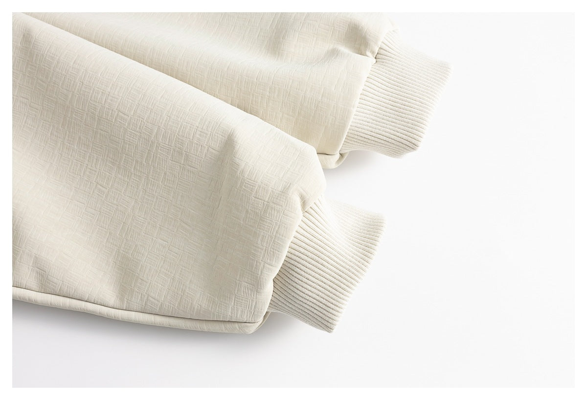 Close-up of the cream jacket's textured sleeves and ribbed knit cuffs.