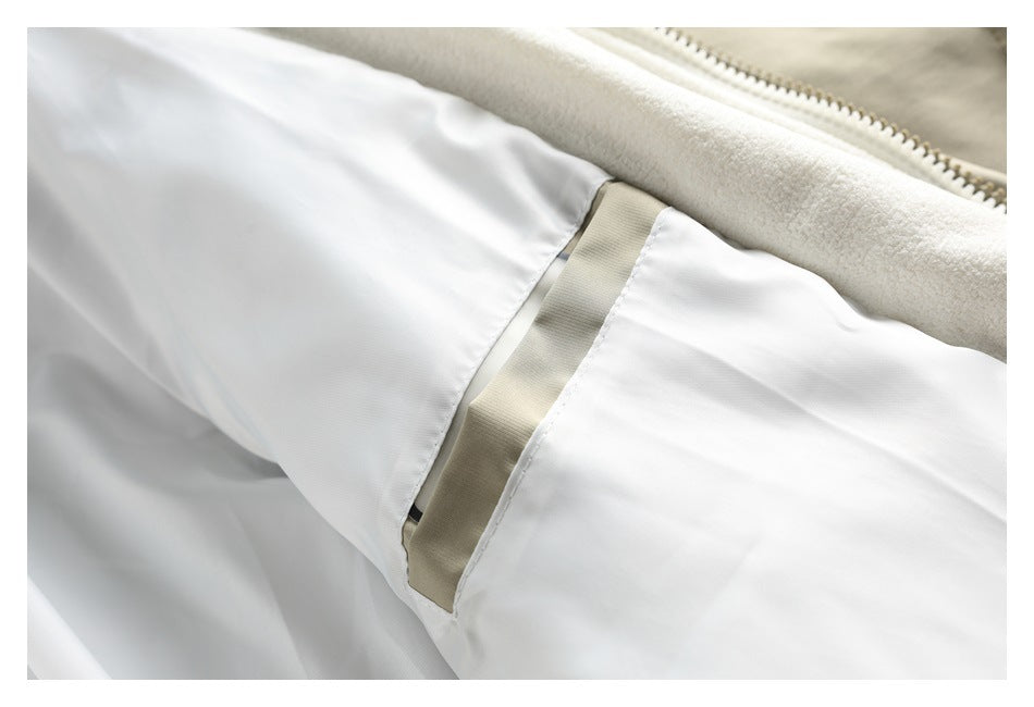 Close-up inside the jacket showing the cream lining, zipper, and taupe-trimmed pocket opening.