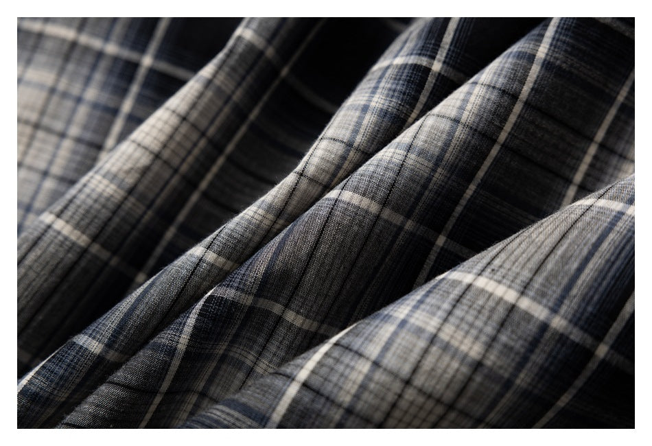 Close-up of the black, gray, and cream plaid fabric draped in soft folds.