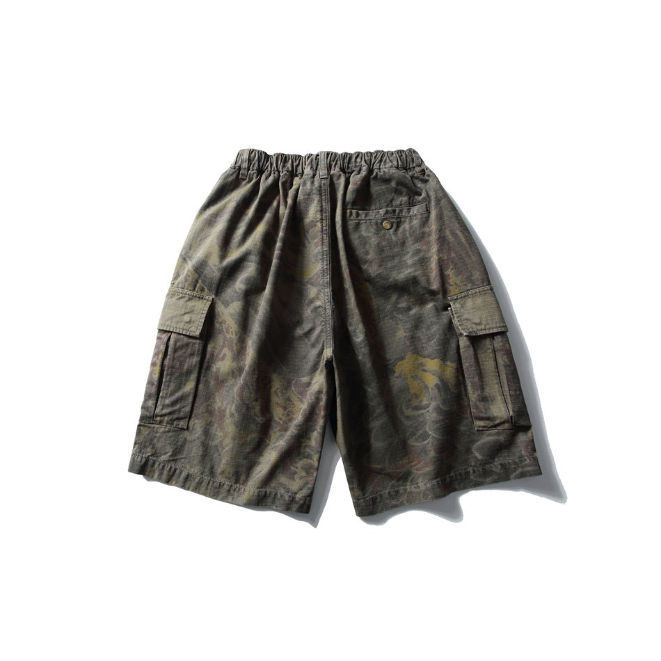 Back view of olive-gray patterned cargo shorts with an elastic waist, buttoned rear pocket, and side cargo pockets.