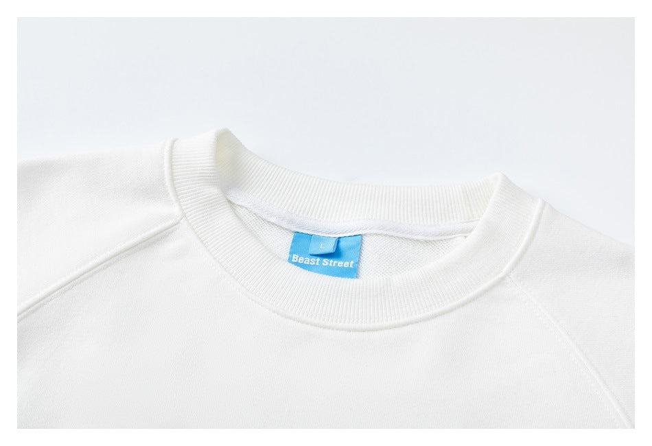 Close-up of the ribbed neckline and blue brand label on a white sweatshirt.