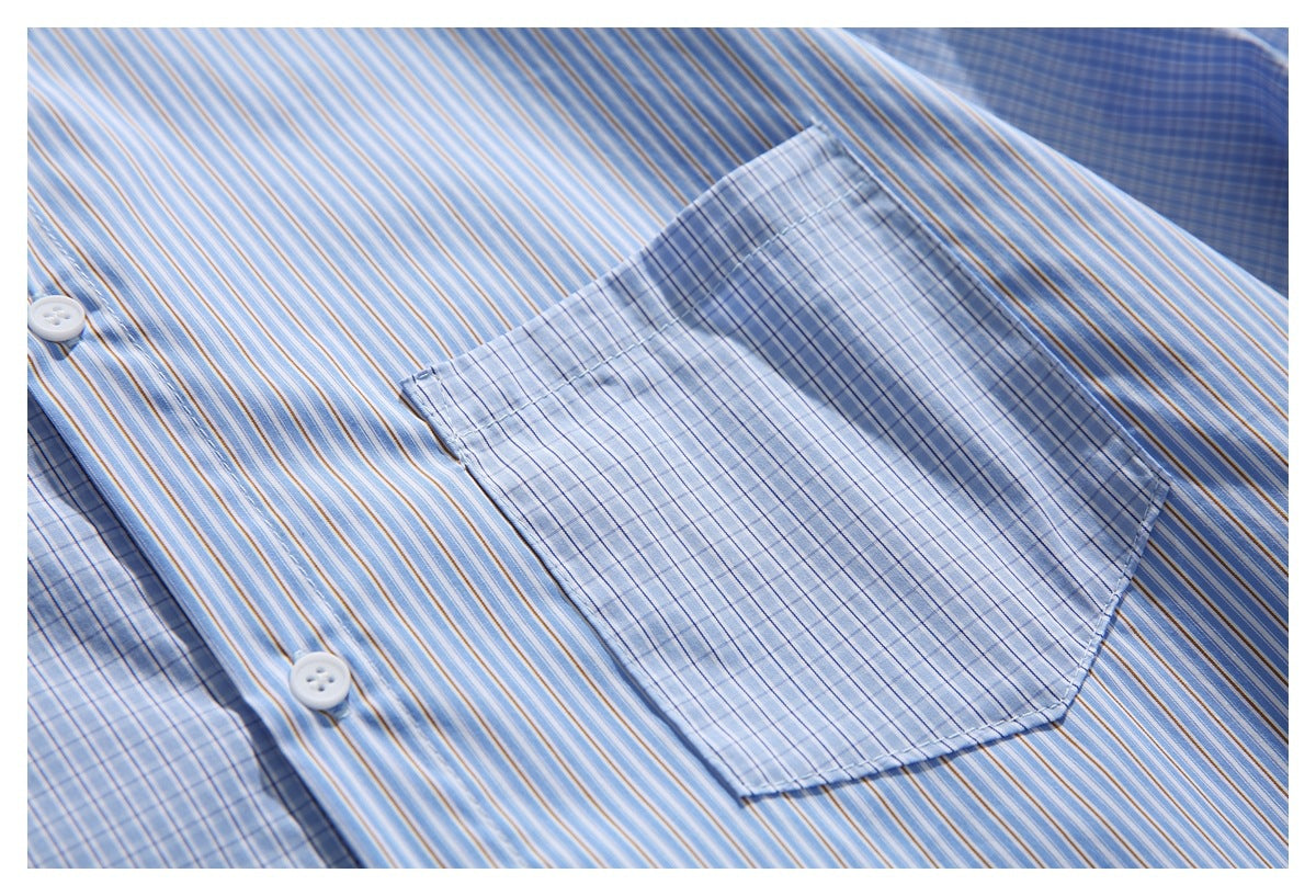 Close-up of a pale blue checked chest pocket on a blue and tan striped shirt, with white buttons.