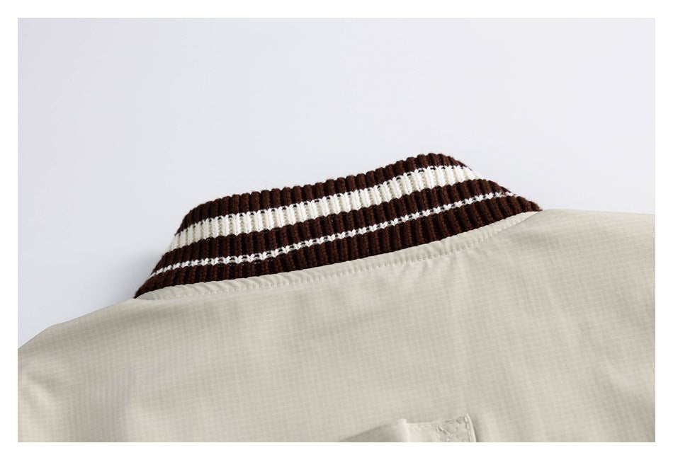 Close-up of the beige jacket collar with dark brown ribbing and white stripes.