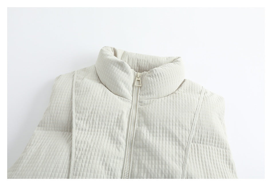 Close-up of an ivory quilted garment with a high stand collar and front zipper.