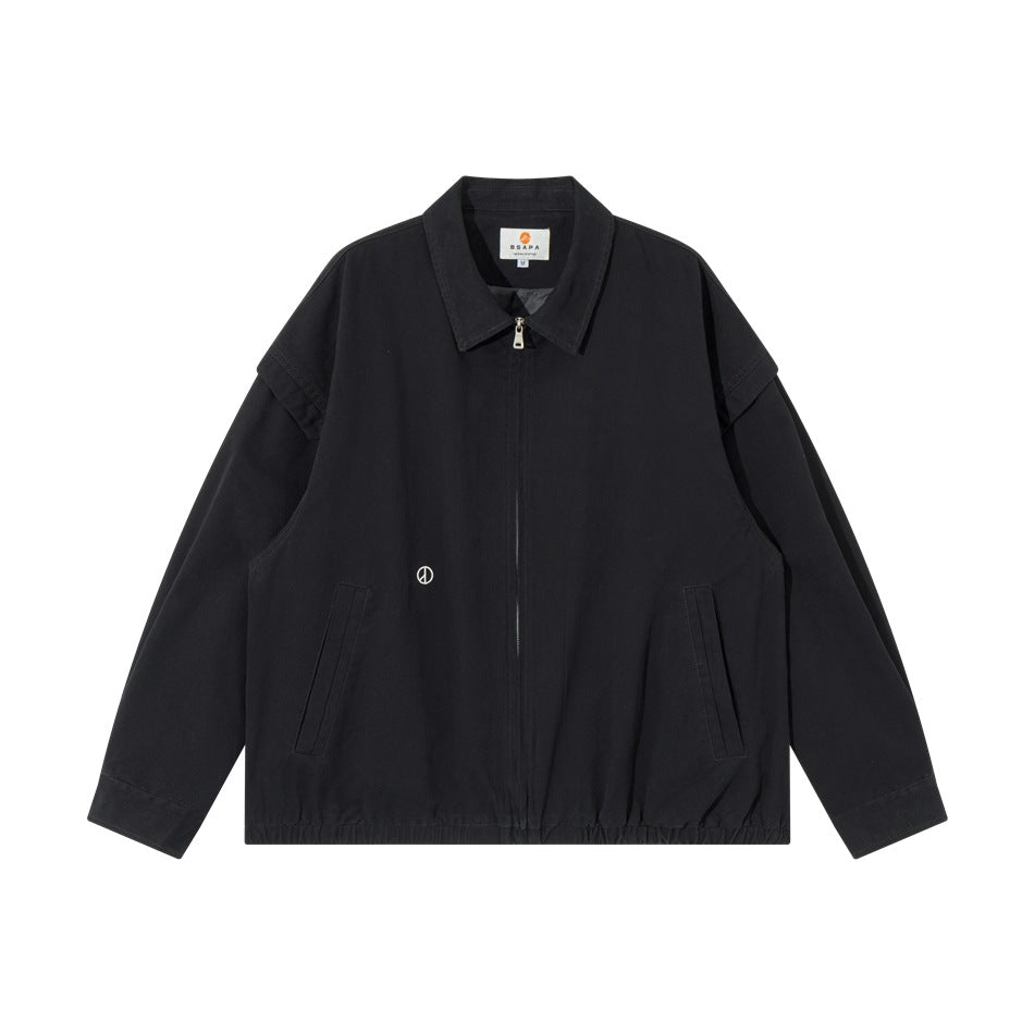 Black collared zip-front jacket flat lay with angled front pockets, elastic hem and small embroidered peace symbol