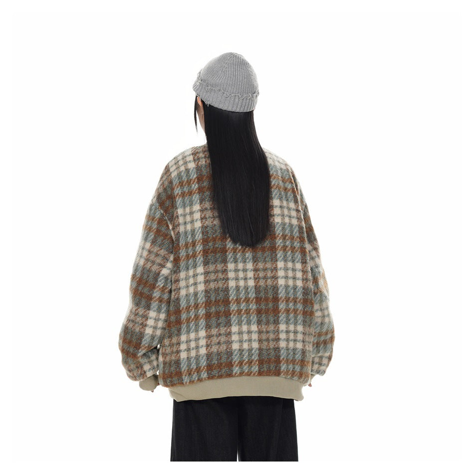 Back view of a model wearing a blue-gray, cream, and rust plaid jacket with beige ribbed hem and cuffs.