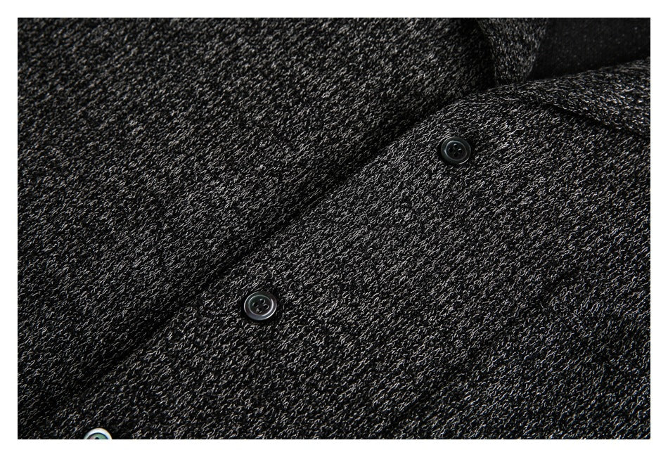 Close-up of dark textured fabric with several black buttons.
