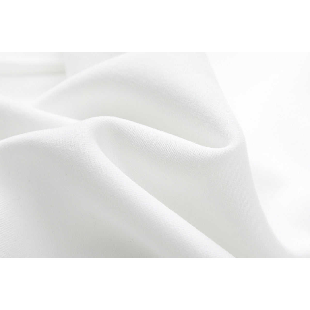 Close-up of softly folded white fabric showing its fine surface texture.