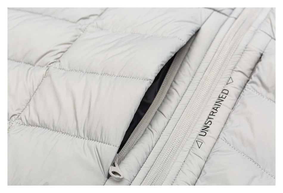 Close-up of a light gray quilted jacket showing an open side pocket beside the main zipper.