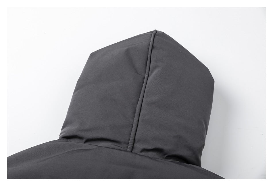 Close-up of a charcoal garment hood with a central seam and part of the upper body visible.