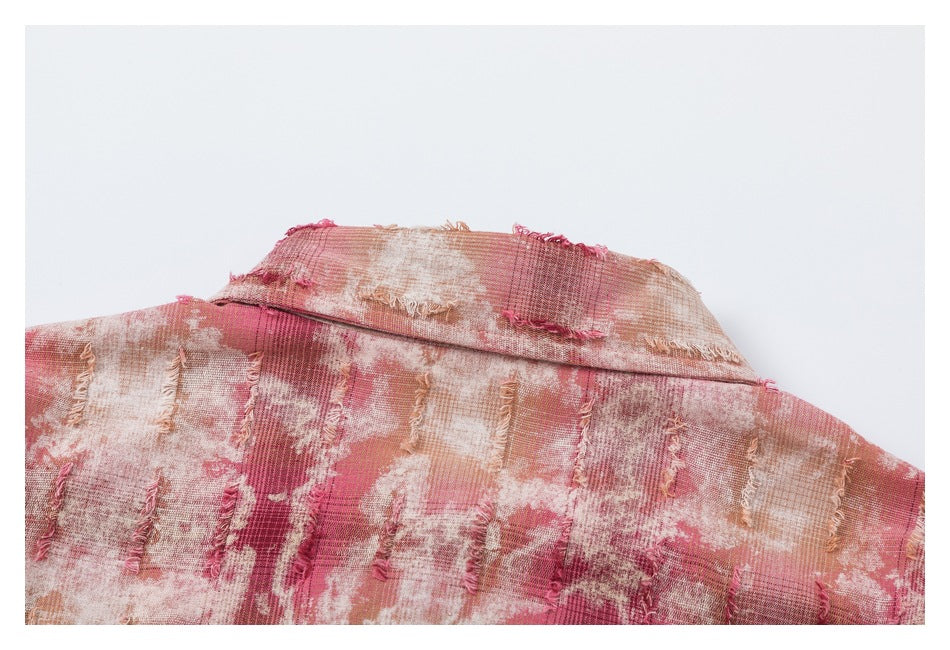 Close-up of a dusty rose and cream checked garment collar with frayed vertical fabric details.