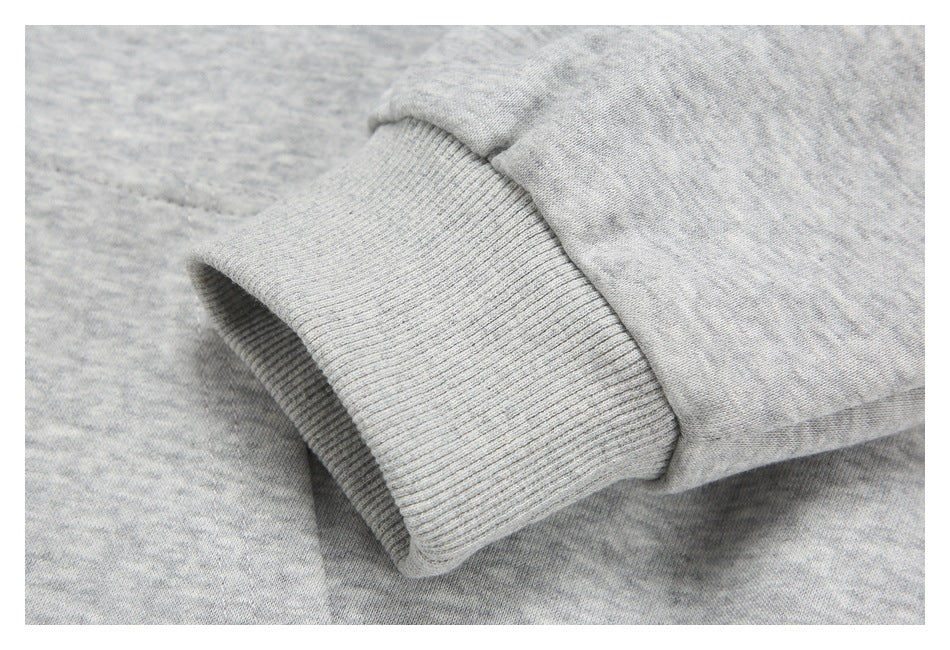 Close-up of a ribbed cuff attached to a light heather-gray sleeve.