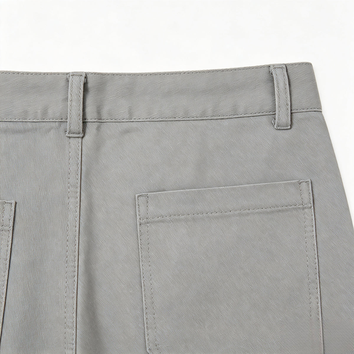 Close-up of gray trousers showing the back waistband, belt loops and a large rear patch pocket.