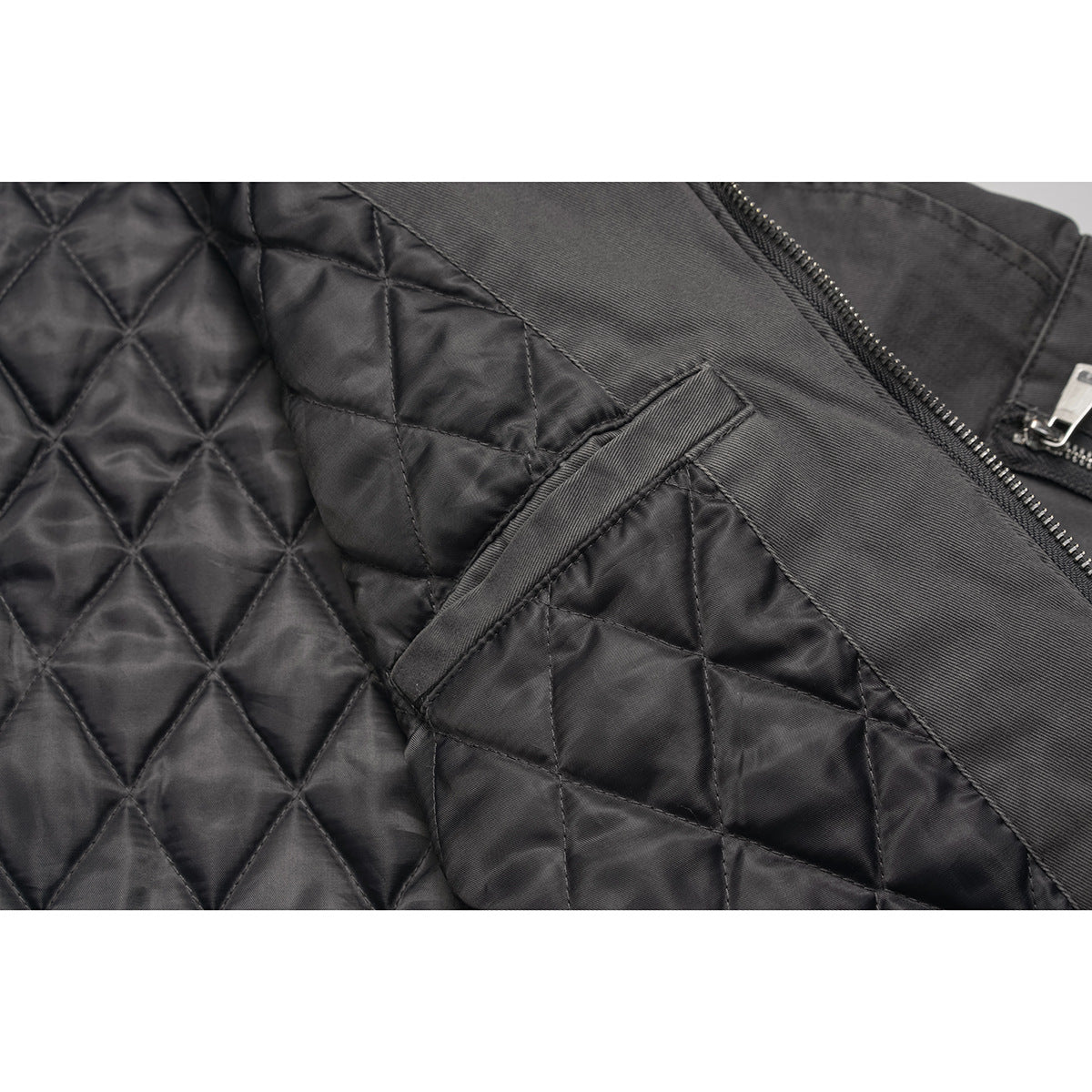 Close-up of a black diamond-quilted jacket lining and interior pocket.