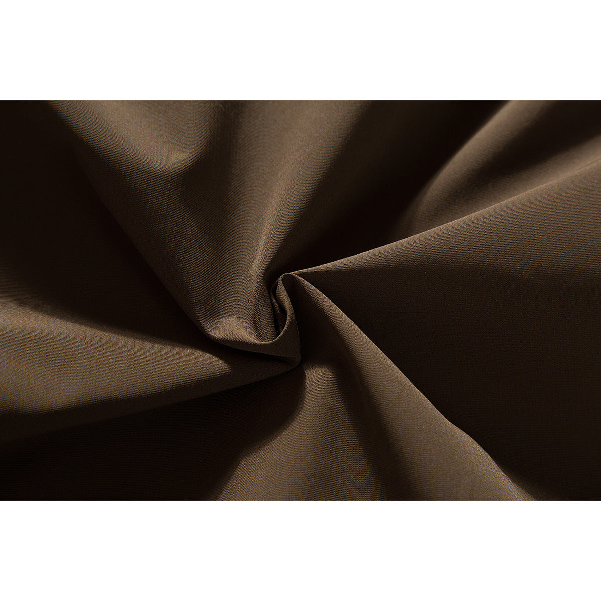 Macro view of dark brown jacket fabric gathered into soft folds.