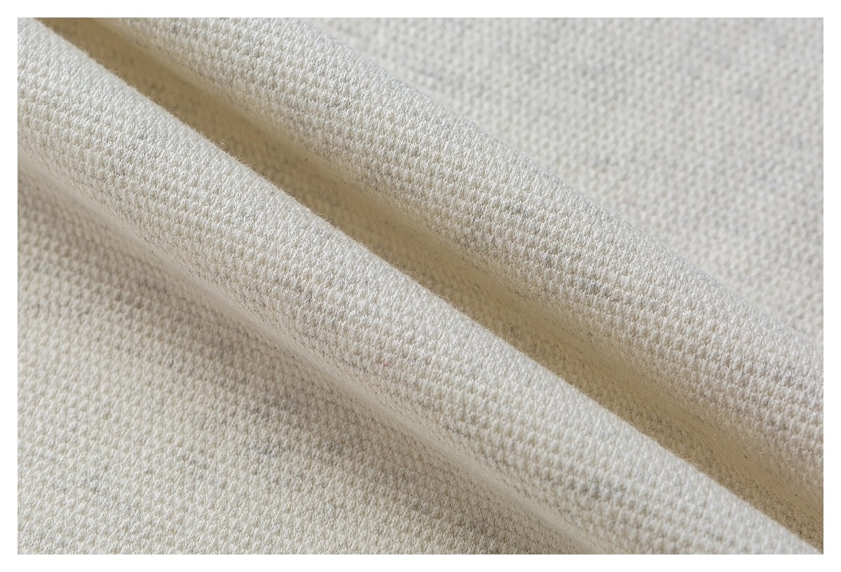 Close-up of folded ivory fabric showing its textured surface and edge.
