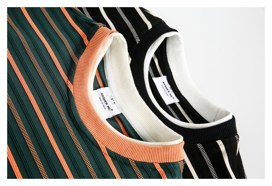 Close-up of the ribbed necklines and striped fabric on green-and-orange and black-and-white tops.