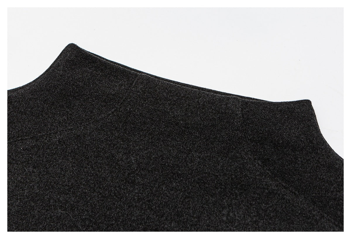Close-up of dark charcoal fabric laid flat, showing a curved garment edge against a white background.