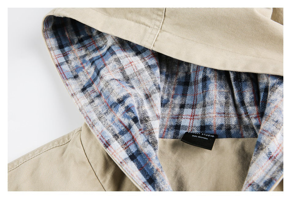 Close-up of the beige jacket's hood, showing blue, gray, and rust plaid lining and a small black neck label.