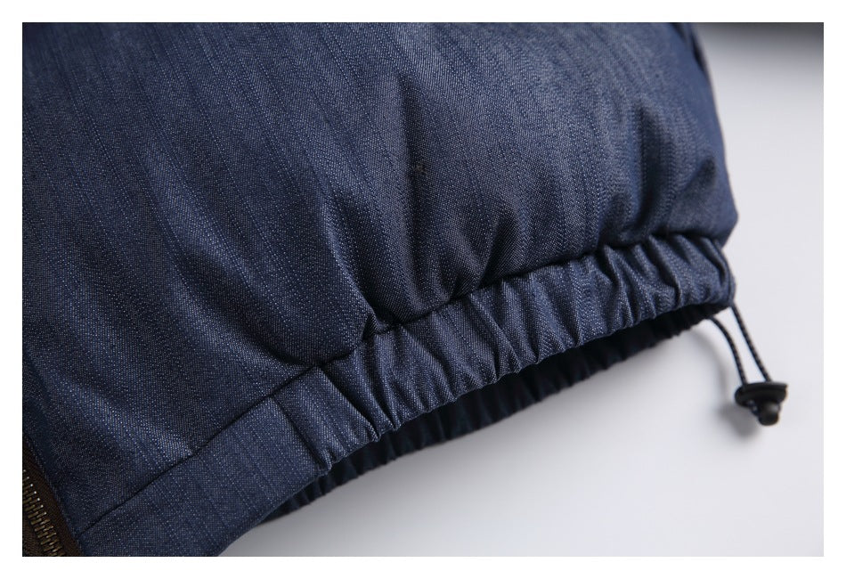 Close-up of the gathered elastic hem and adjustable drawcord on a dark blue jacket.