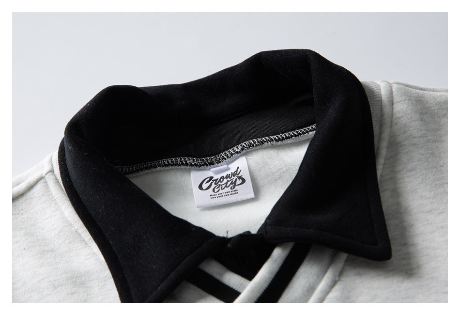 Close-up of a light gray sweatshirt’s black collar and sewn neck label.