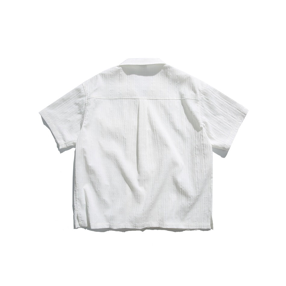Back view of a white short-sleeve shirt with a horizontal yoke seam and subtle vertical stripe texture.