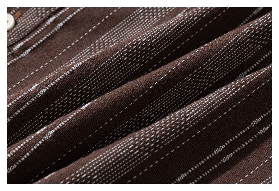 Macro view of brown fabric with textured white stripe patterns and folds.