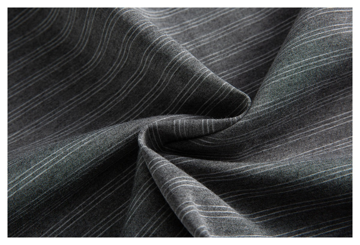 Close-up of the charcoal gray shirt's fine light stripes arranged in soft folds.