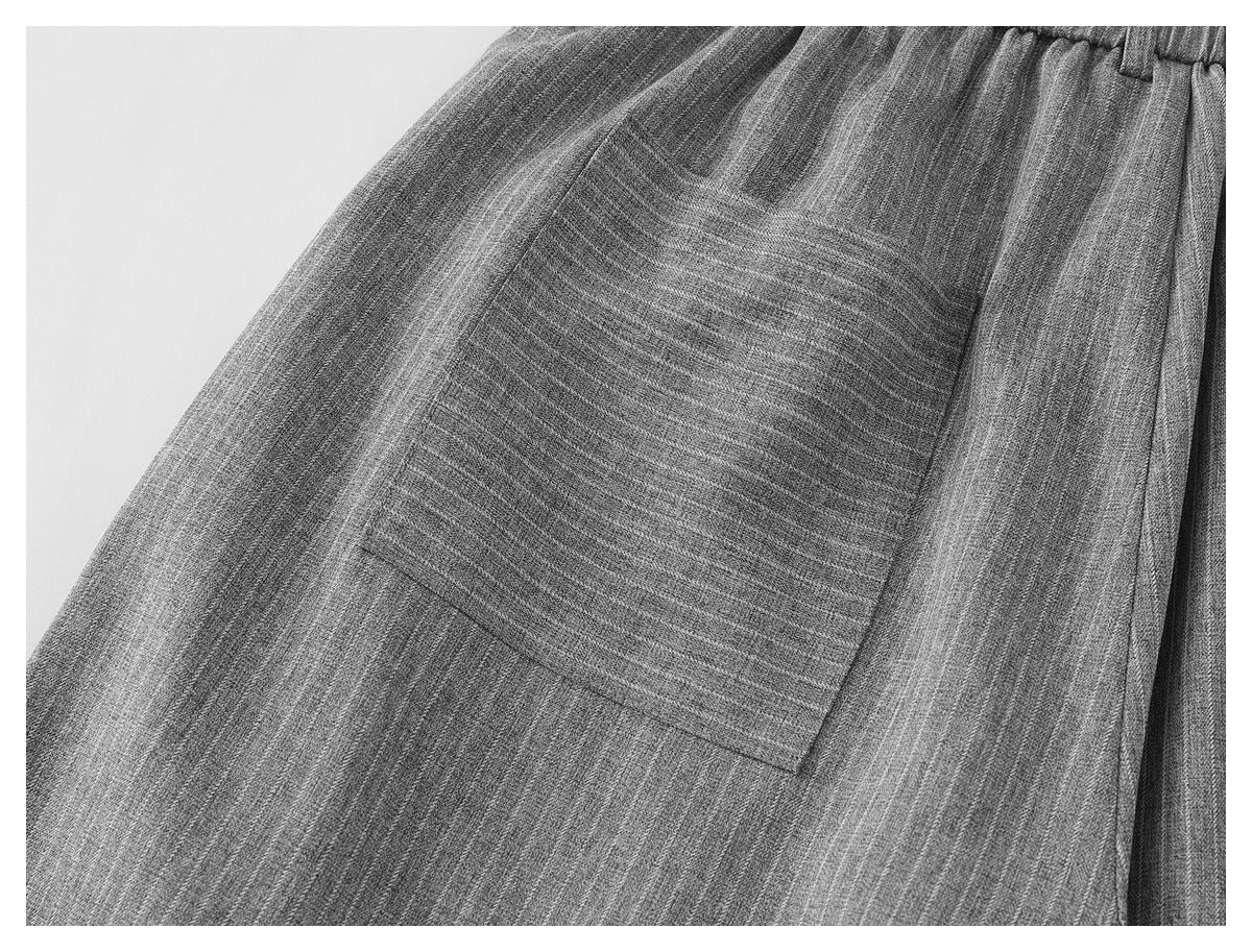 Close-up of a patch pocket on gray pinstriped trousers.