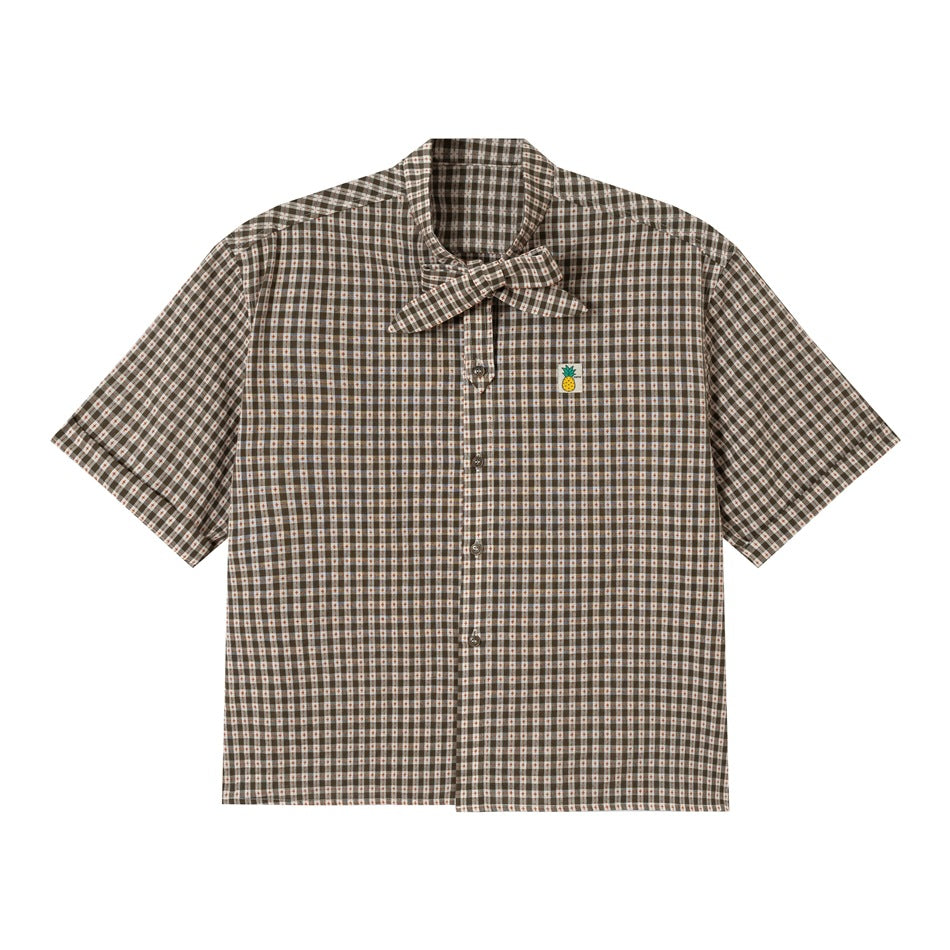 Flat front view of a short-sleeve brown and cream plaid button shirt with a bow tie collar and pineapple patch