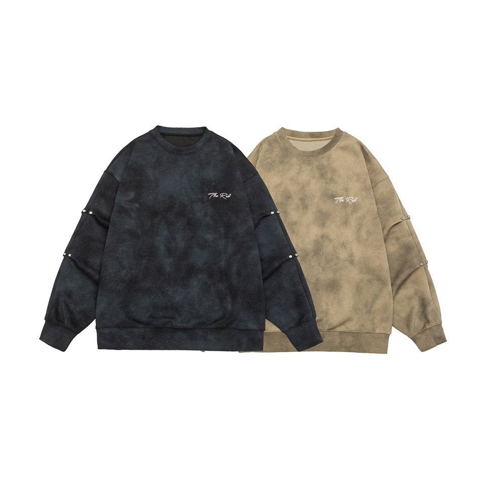 Two oversized sweatshirts shown flat: dark navy and taupe, both with white chest script and sleeve studs.