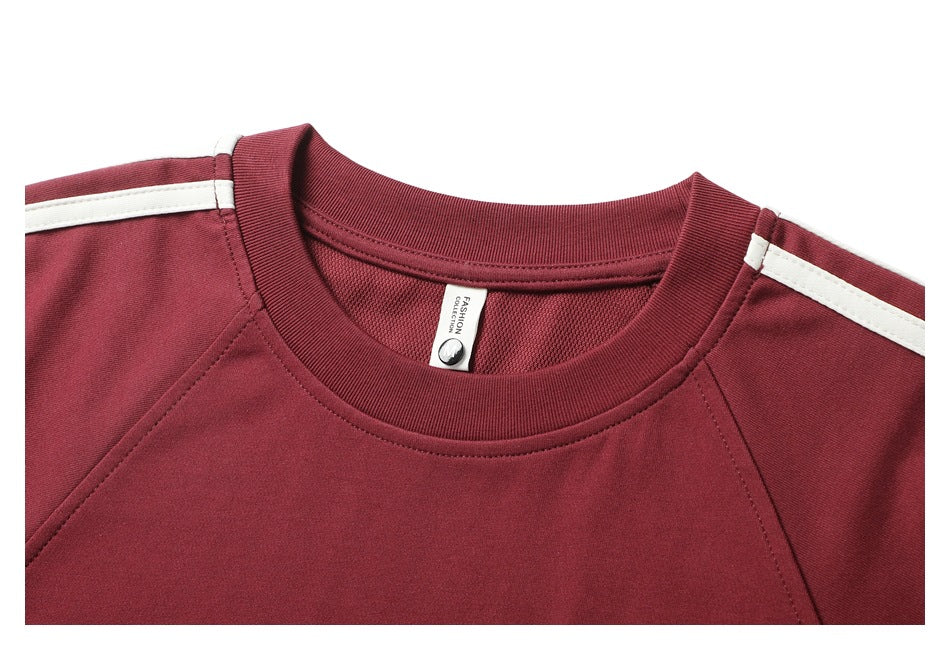 Close-up of the burgundy shirt’s ribbed crew neck, inner label and white shoulder stripe.