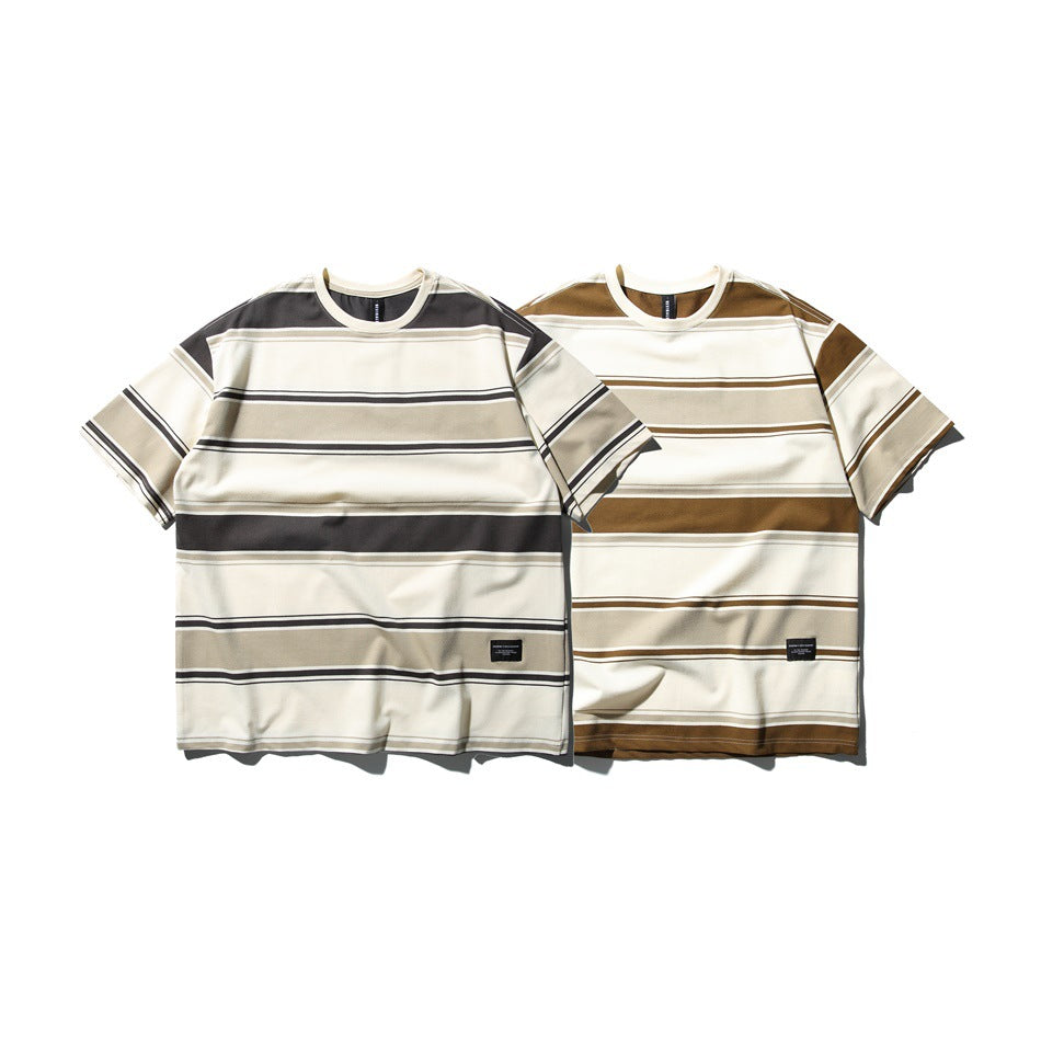Two front-facing striped crew-neck T-shirts: one cream with charcoal and taupe bands, the other cream with brown and taupe
