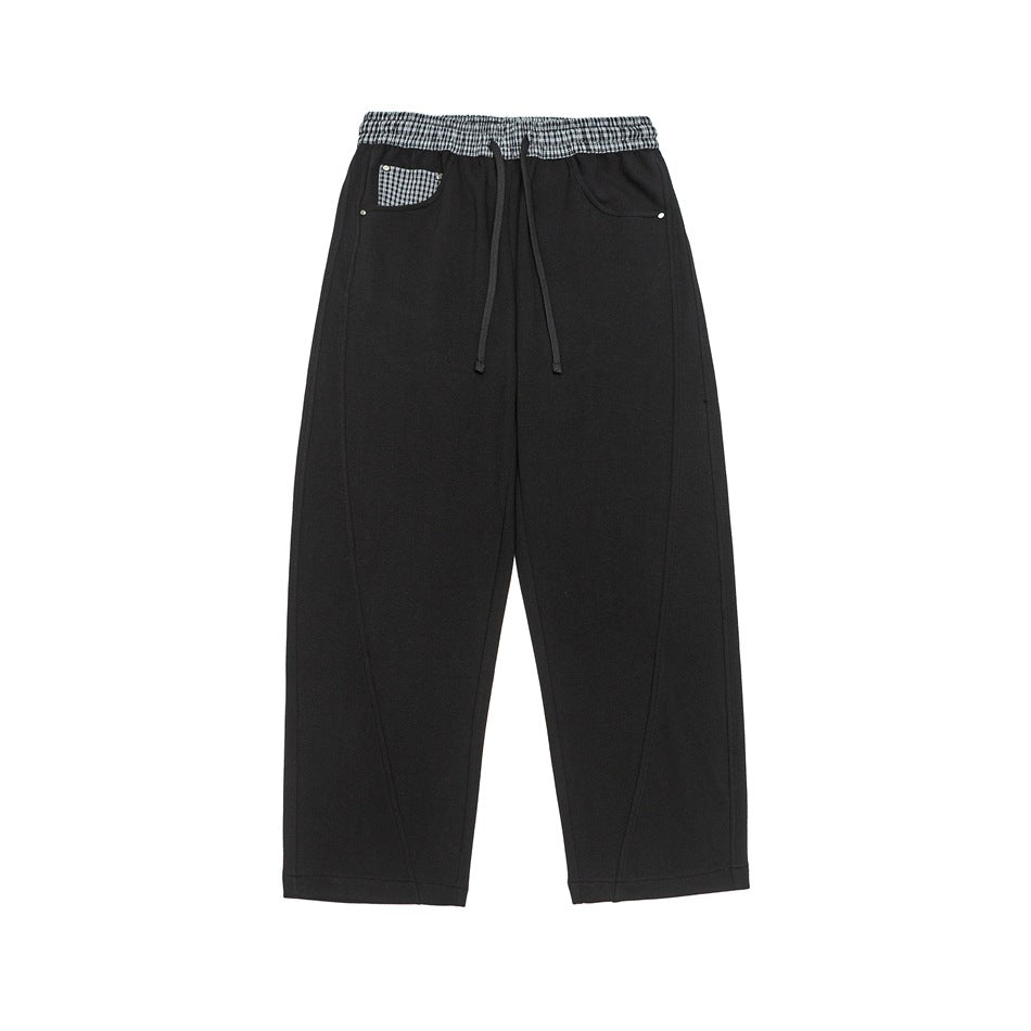 Black wide-leg drawstring pants with plaid waistband and plaid pocket patch, flat lay front view