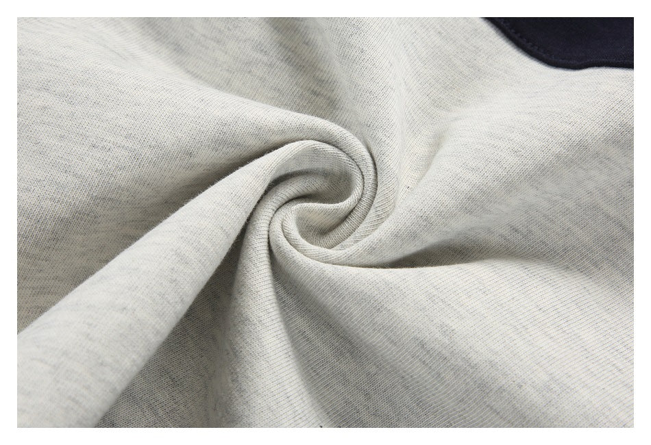 Close-up of light heather-gray fabric gathered into a twist, with a dark navy section visible at the edge.