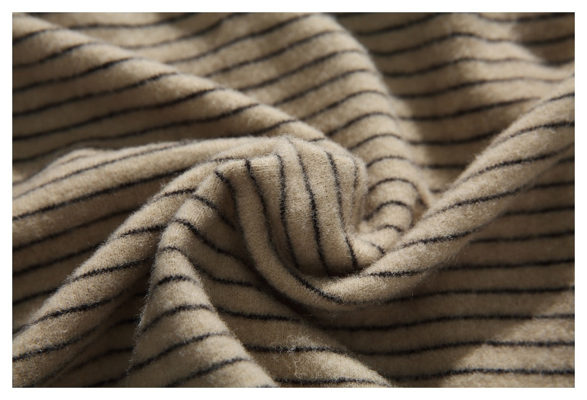 Close-up of fuzzy beige fabric with thin dark stripes, loosely gathered to show its texture.
