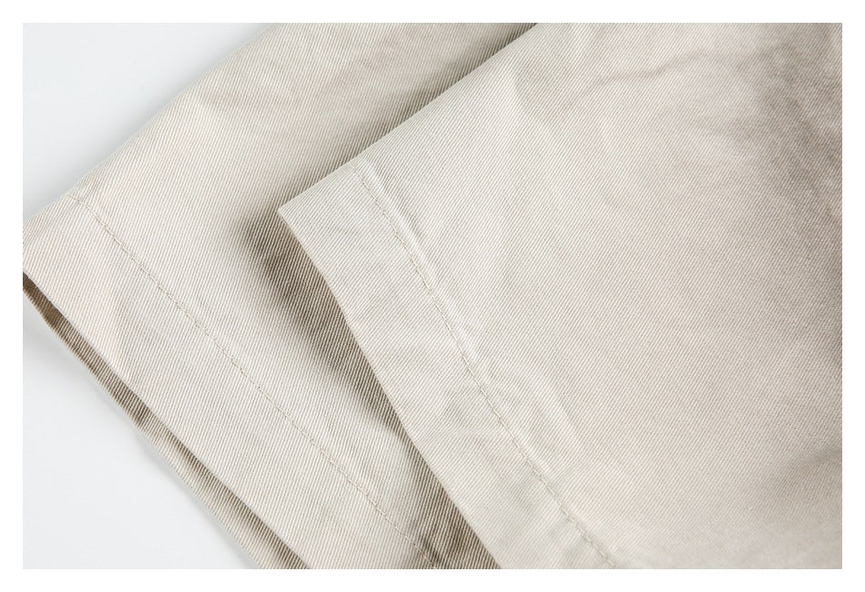 Close-up of overlapping light beige fabric panels with neat edge stitching.